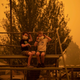 Children wear masks as they play near the town of Bega, Australia where people are camping after being evacuated from nearby sites affected by bushfires on December 31, 2019.